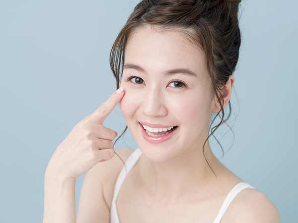 目元を指さしている女性